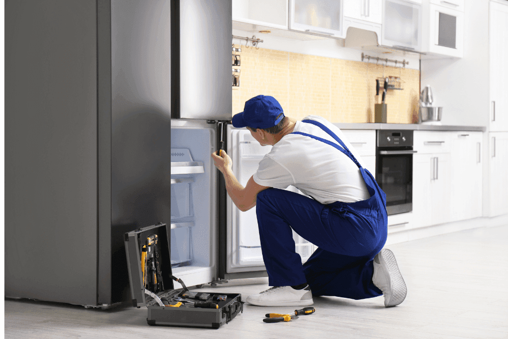 Certified refrigerator repair technician in Dubai fixing a modern French door fridge